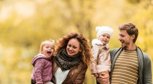 Young playful family taking a walk during autumn day.